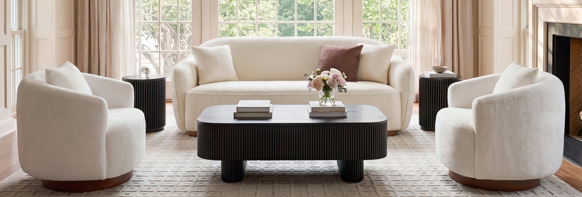 Highlighting key types of furniture, this living room features a bouclé sofa, armchairs, and a fluted coffee table.