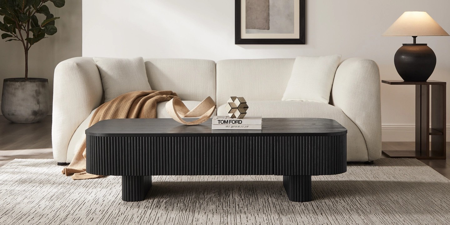 Marisol 55.1-inch black oak coffee table with a 15-inch coffee table height, featuring fluted details and a modern aesthetic, set in a cozy, neutral-toned living room.