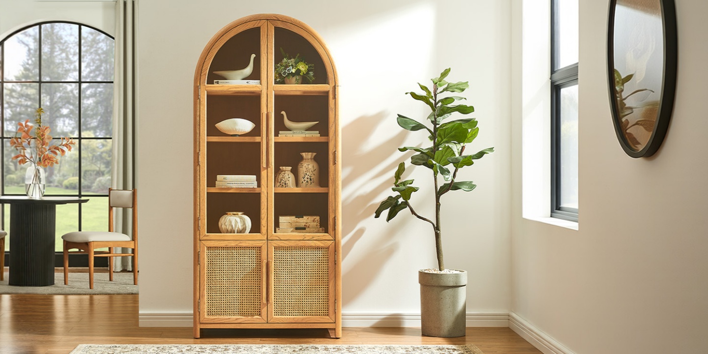 36-inch Alvborg natural oak rattan bookcase featuring arched glass top doors and lower woven panels, displayed in a bright modern home. 36-inch Alvborg natural oak rattan bookcase featuring arched glass top doors and lower woven panels, displayed in a bright modern home.