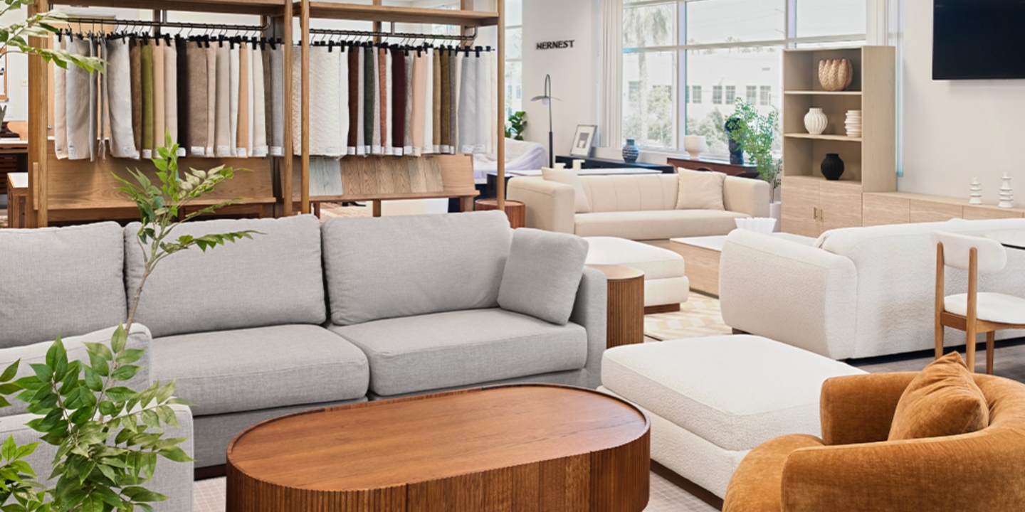 Bright modern Hernest furniture showroom showcasing fabric sample swatches, contemporary sofas, and cozy living room displays. Bright modern Hernest furniture showroom showcasing fabric sample swatches, contemporary sofas, and cozy living room displays.