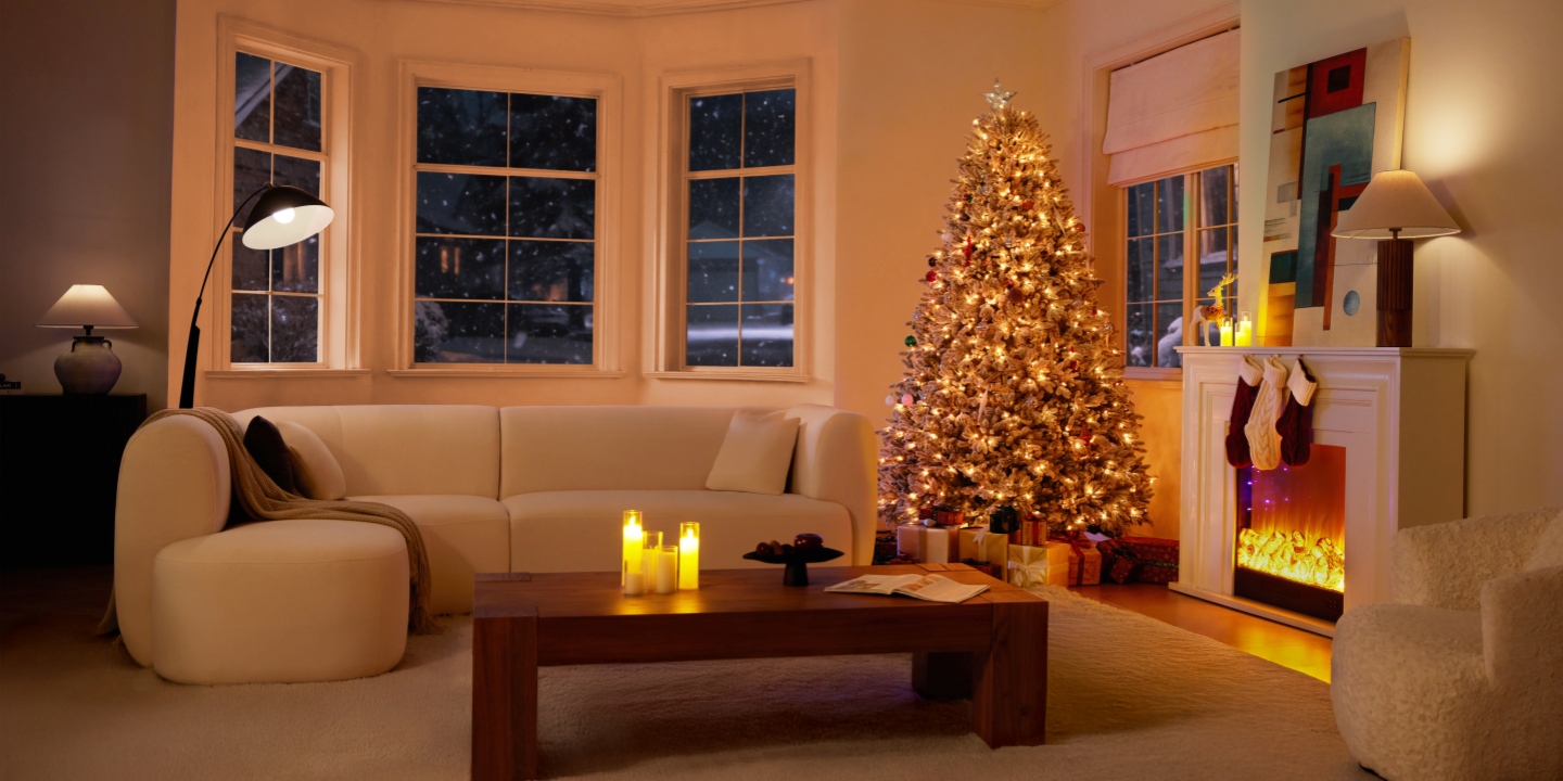Cozy holiday living room featuring the Hernest CastGlow artificial Christmas tree with warm lights and a cozy fireplace.