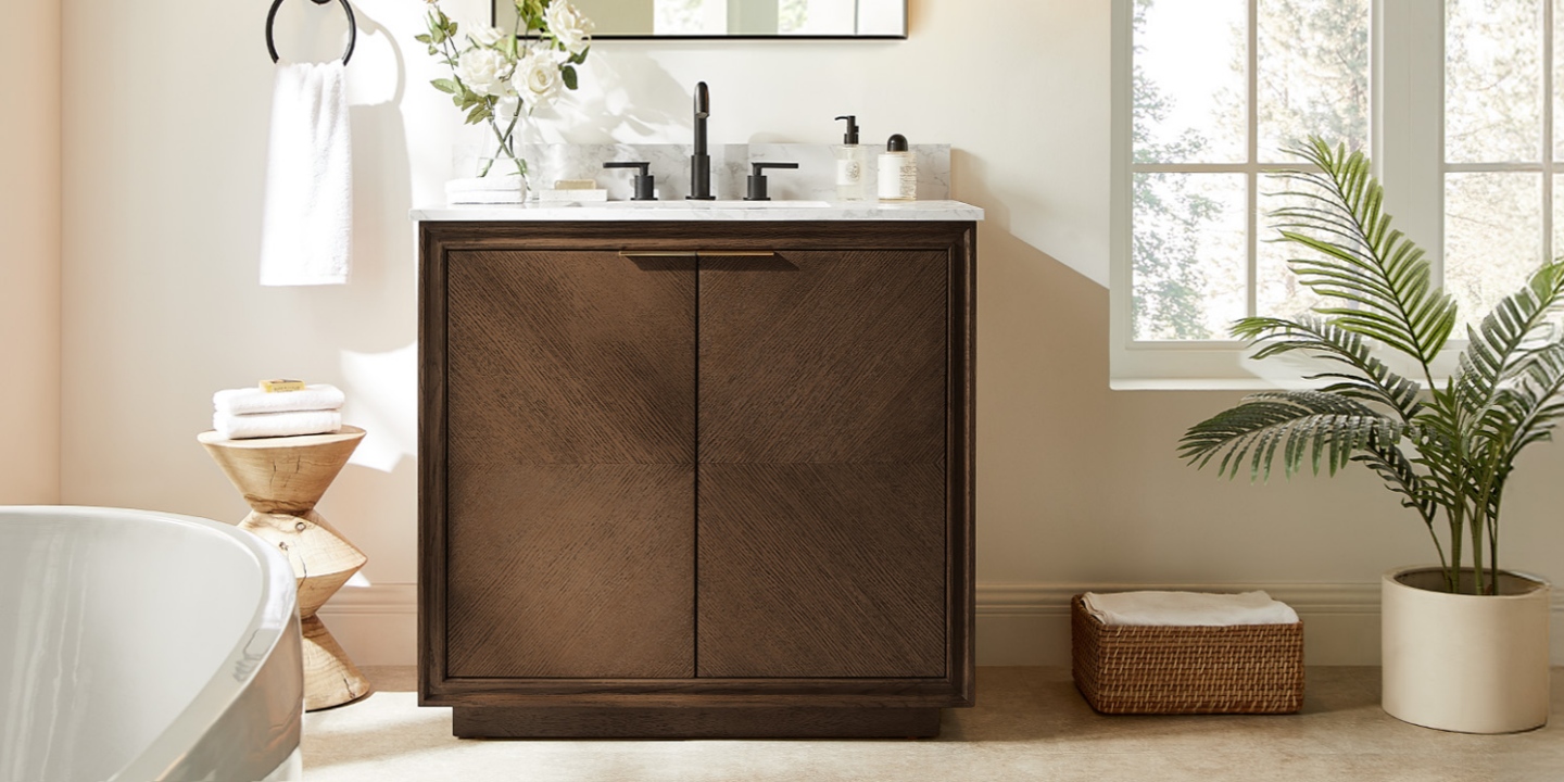 The 36-inch Thursen single bathroom vanity stands in a bright room between a potted plant and a bathtub. The 36-inch Thursen single bathroom vanity stands in a bright room between a potted plant and a bathtub.