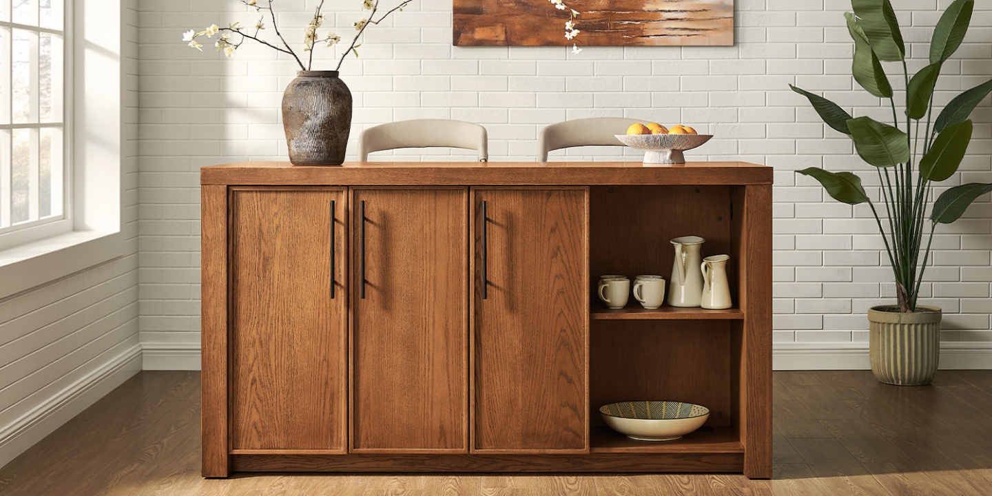 The 69-inch Niklas oak kitchen island features closed cabinets and open shelving, styled with counter stools against a white brick wall. The 69-inch Niklas oak kitchen island features closed cabinets and open shelving, styled with counter stools against a white brick wall.