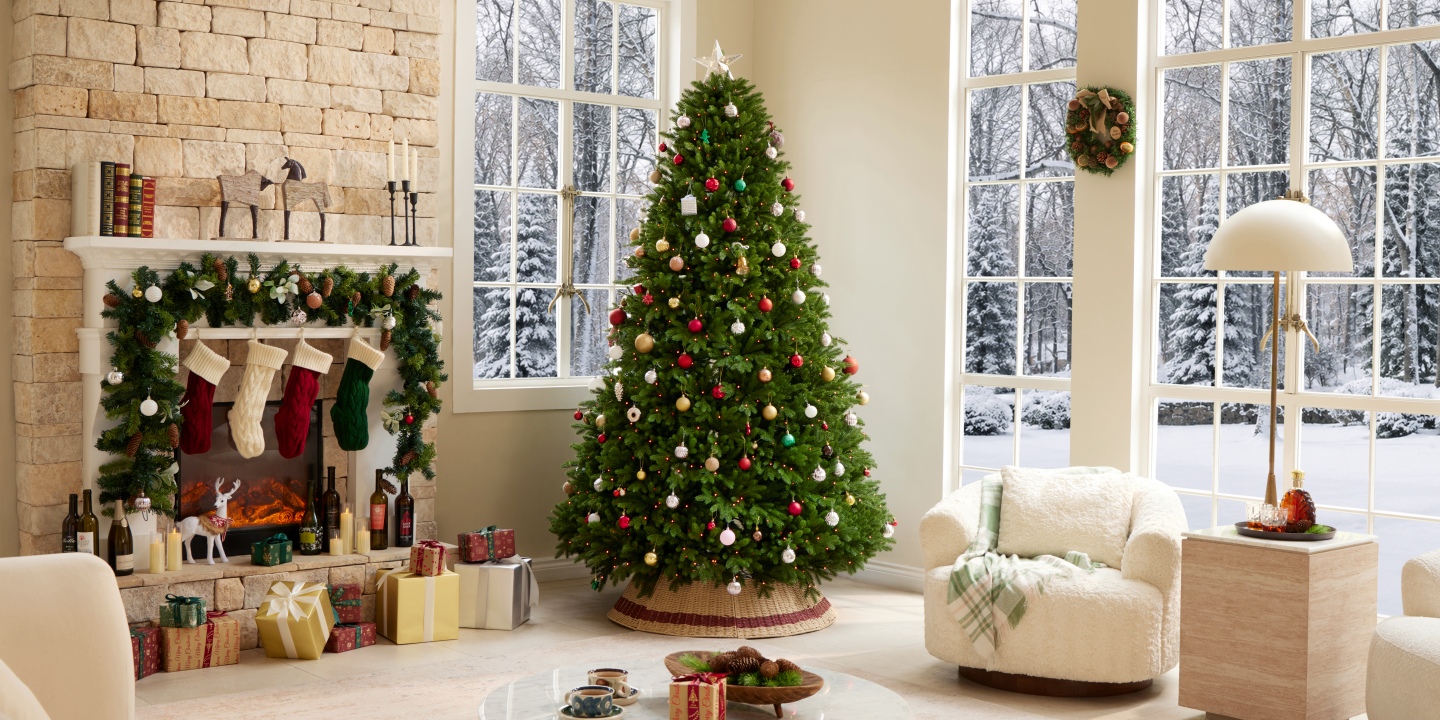 Festive holiday living room featuring the Hernest CastGlow artificial Christmas tree with colorful ornaments.