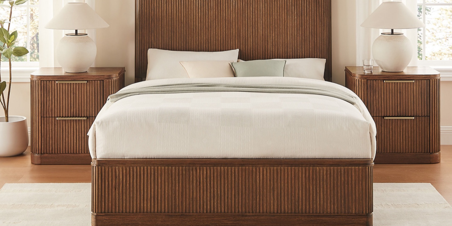 Bedroom with a fluted bed and two matching nightstands. The bed is styled with a cream duvet, green throw. Bedroom with a fluted bed and two matching nightstands. The bed is styled with a cream duvet, green throw.