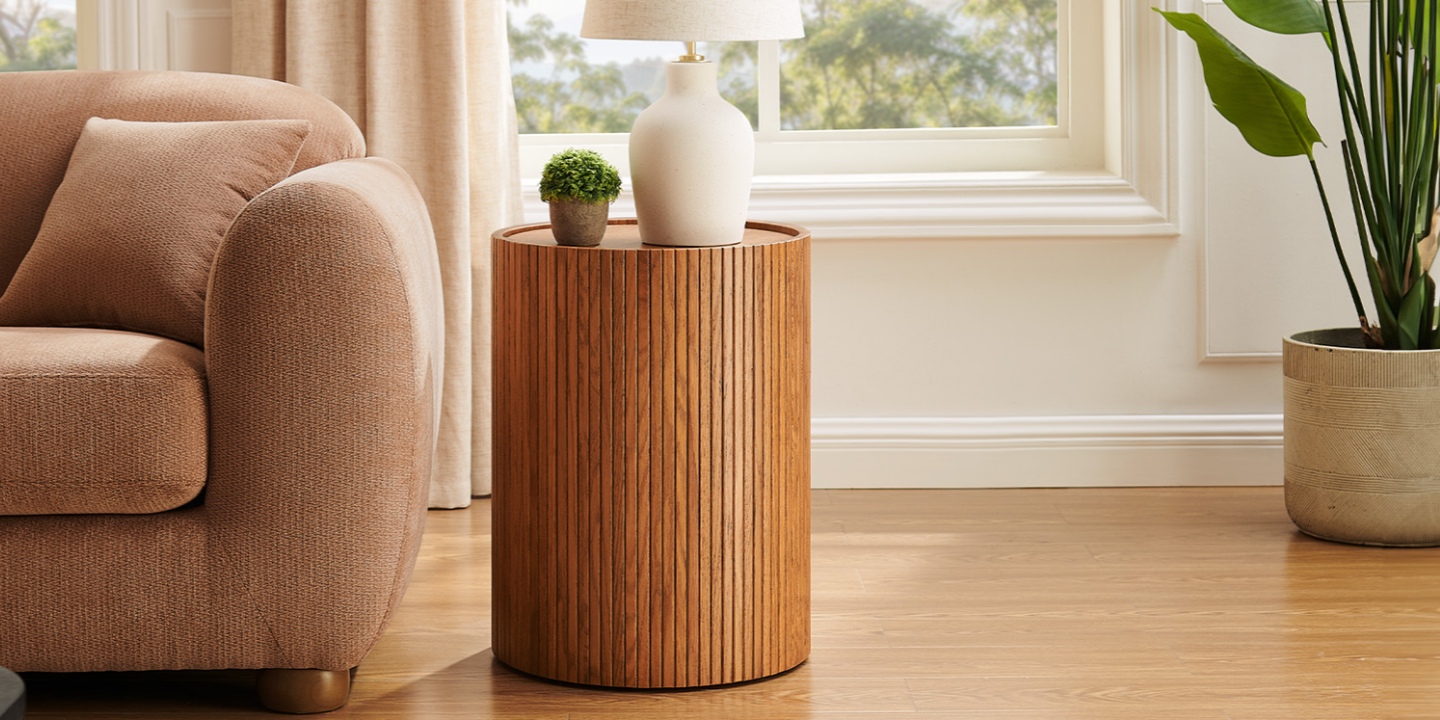 A round fluted oak side table stands beside a sofa, providing concealed storage for stuffed animals. A round fluted oak side table stands beside a sofa, providing concealed storage for stuffed animals.