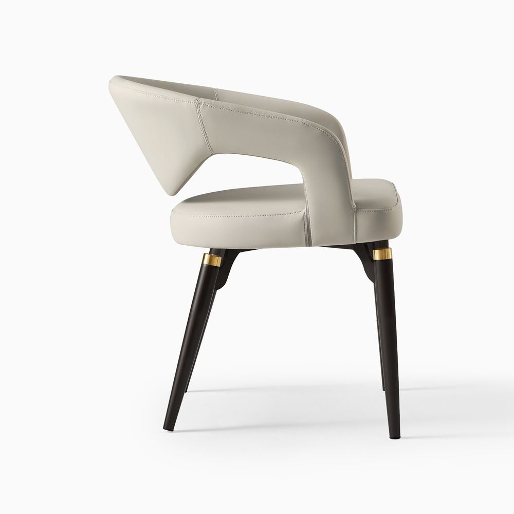 Close-up of the Hernest Liliana Armrest Leather Dining Chair, highlighting the stitched beige PU leather seat and the leg accent.