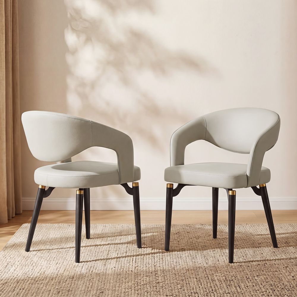 Orange DinTwo modern beige Hernest Liliana Armrest Leather Dining Chairs with curved backs and gold-accented black legs, shown together.ing Chair Set