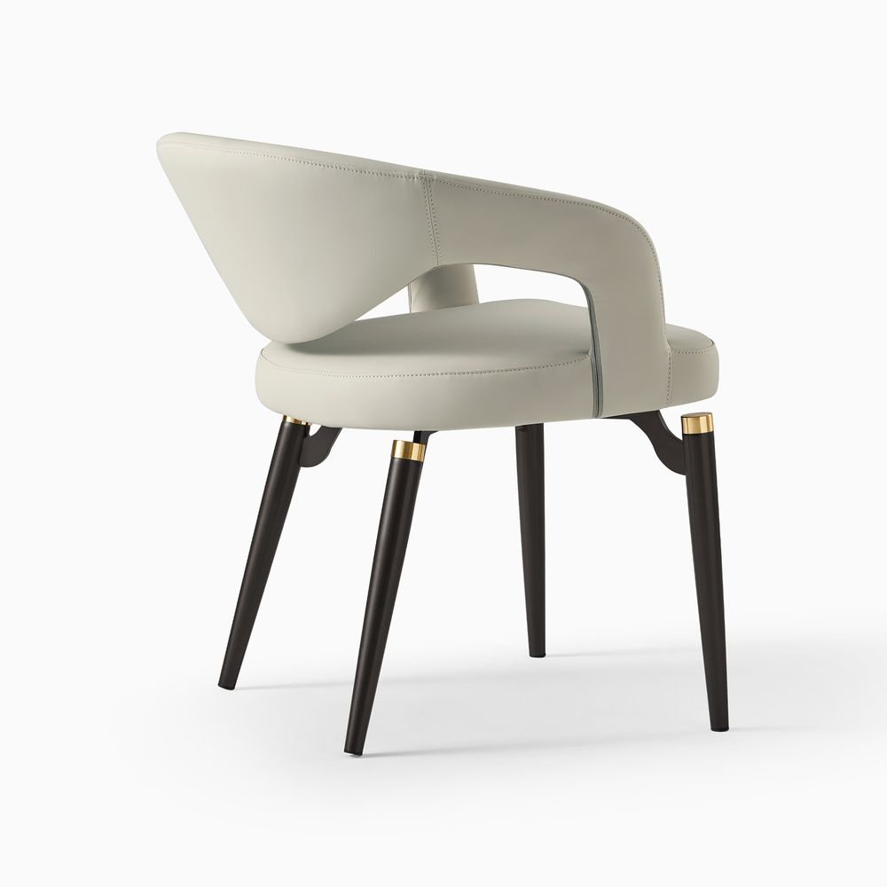Front view of the Hernest Liliana Armrest Leather Dining Chair in beige, featuring its signature curved backrest and gold-accented legs.