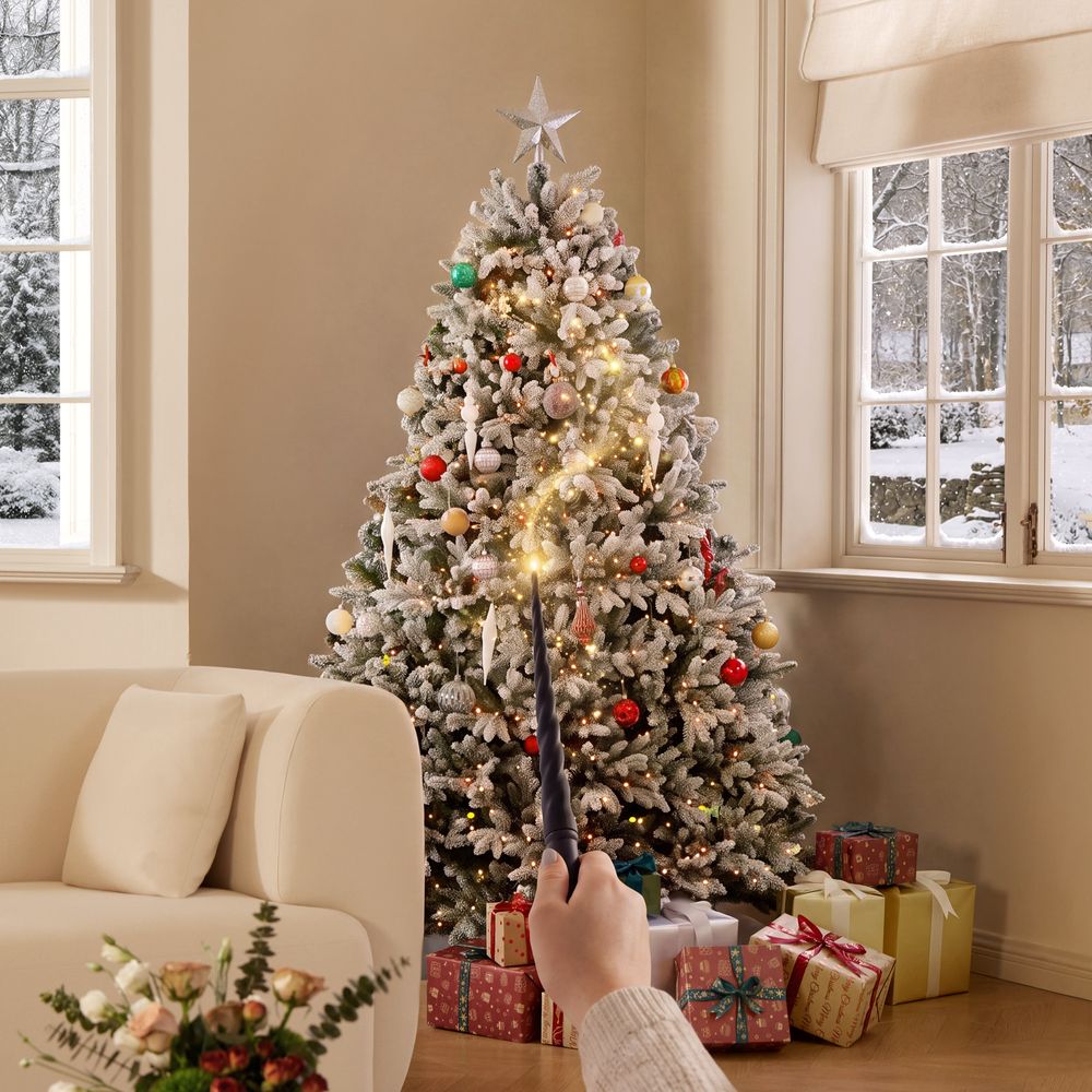 Cozy living room featuring the CastGlow 6.5 ft pre-lit flocked artificial Christmas tree controlled by a magic wand.