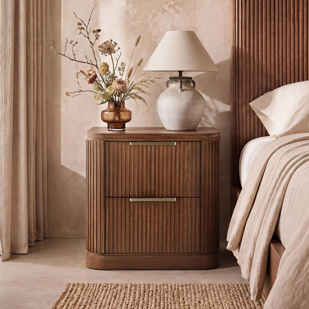 Hernest Finnley 26 inch Fluted Nightstand in a bedroom setting, showcasing two drawers with metal hardware and a sophisticated fluted design.