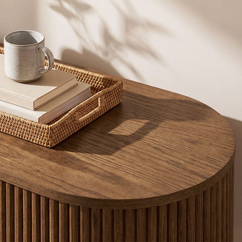 Hernest Rolf 63 inch Oak Sideboard featuring wood's natural grain, elegant fluted base design, rounded edges, and styled with a rattan tray.